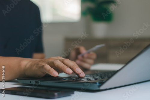 Online shopping concept. A man holding credit card and typing on laptop for online shopping and payment makes a purchase on the Internet, Online payment, Business financial and technology.