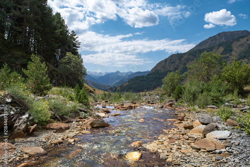 Senderismo por los Pirineos en el Valle de Aran, recorriendo valles y ríos con las montañas al fondo