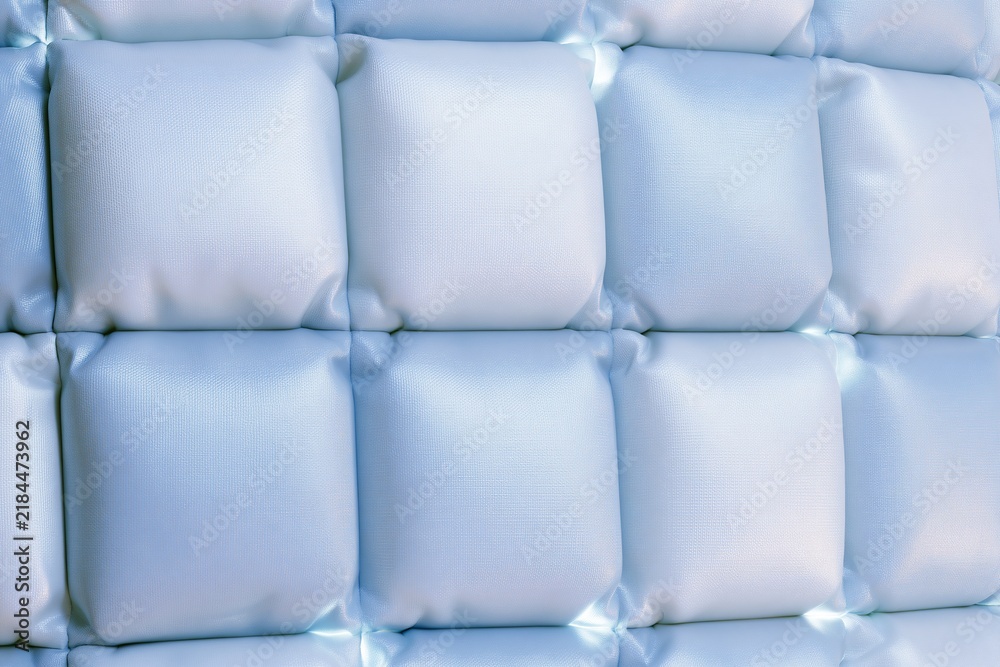 Obraz premium Close up view of padded tufted light blue square puffy quilted wall panel for modern bedroom interior upholstery design decoration