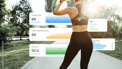 Obraz na płótnie Runner tracks performance data during a running session in a park in daylight