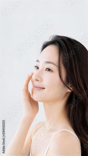 頬に手を添えて上を見つめる女性の横顔
