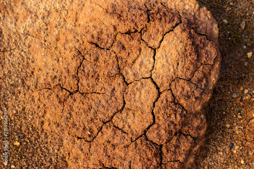 Bild auf Leinwand Close-up overhead view of parched terracotta earth with deep cracks, showcasing