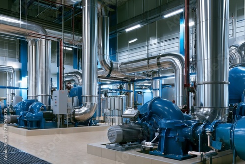 Pipes and machinery inside a large industrial facility in a manufacturing area