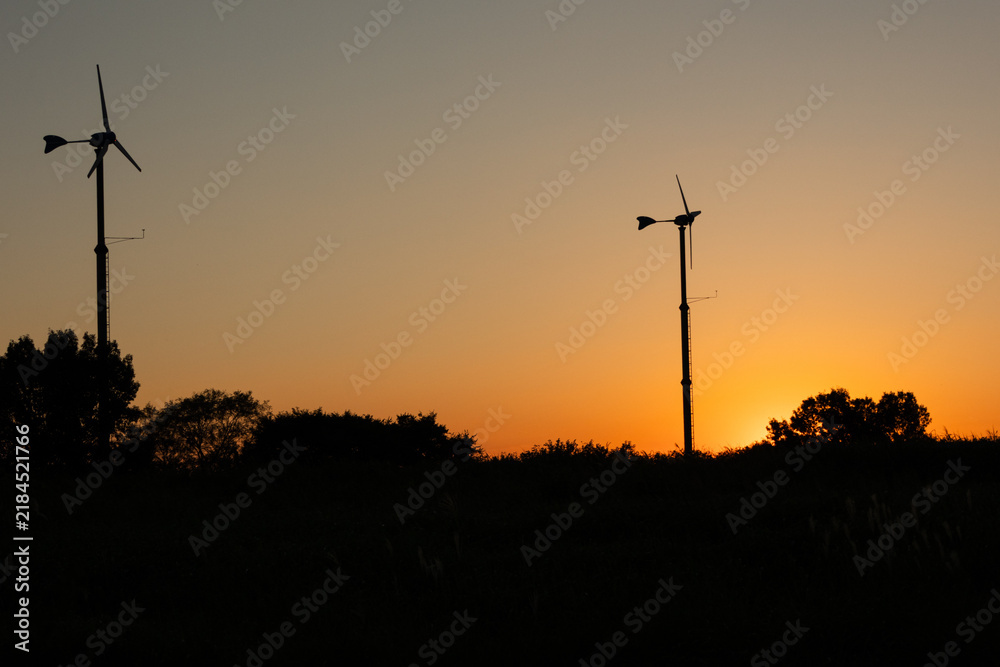 Obraz premium sunset silhouette of wind turbines 
