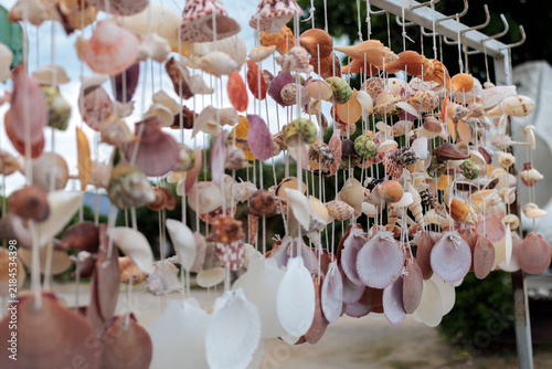 Obraz na plátně Colorful handmade seashell and starfish decorations displayed for sale at an outdoor local market in Thailand, representing coastal crafts, souvenirs and travel shopping