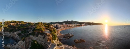 Aerial view taken from a drone of the coast of Lloret de Mar, Costa Brava, Spain, early in the morning at sunrise - the sea, beach and coastal hotels