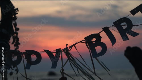 Happy Birthday Banner Hanging on a Beach Tree at Sunset, close up