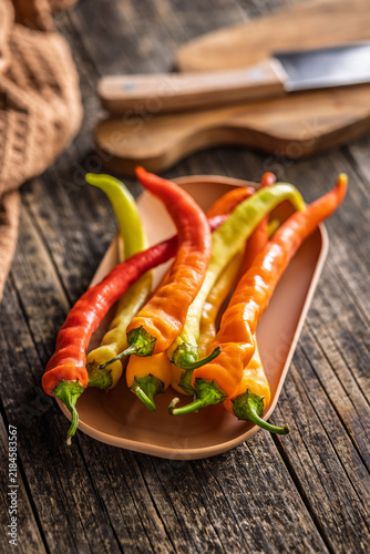 Close-Up of Long Orange and Red Chili Peppers on Rustic Wooden Table Tray, Fresh
