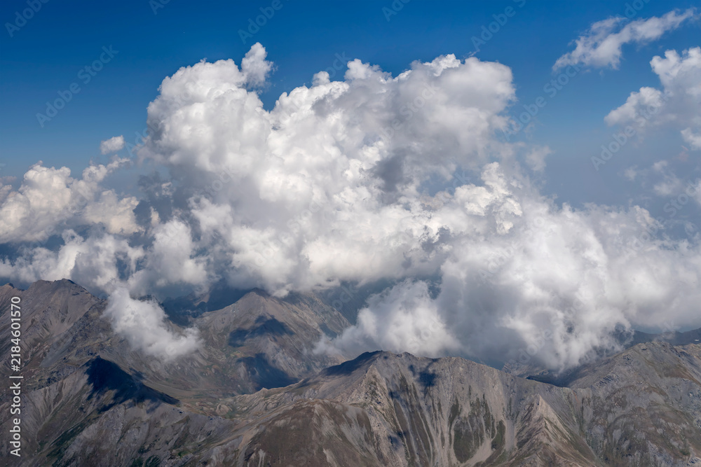 Obraz premium convergence clouds on barren Chisone valley mountains aerial, Italy