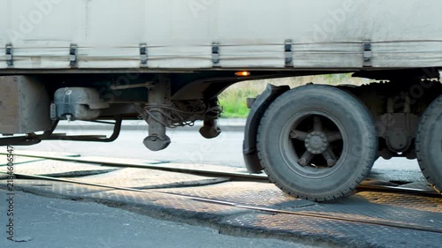Truck with semi-trailer wheels crossing railway tracks