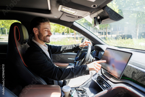 Smiling man interacting with car infotainment system