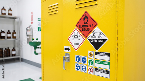 Chemical cabinet with warning labels for hazardous materials  