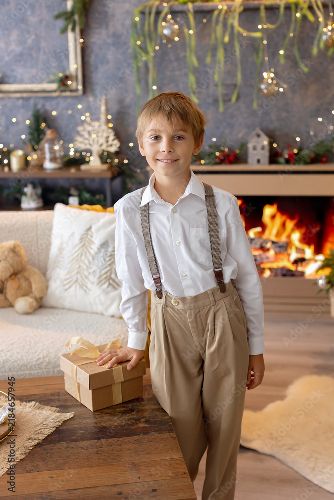 Obraz premium Happy child on Christmas, enjoying some quality time, opening presents, kids on Christmas eve in decorated home