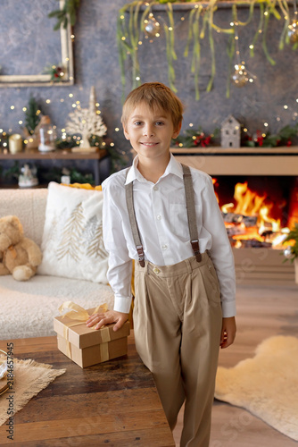 Happy child on Christmas, enjoying some quality time, opening presents, kids on Christmas eve in decorated home