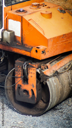 Foto Orange asphalt paving roller machinery detail at construction site road work hea