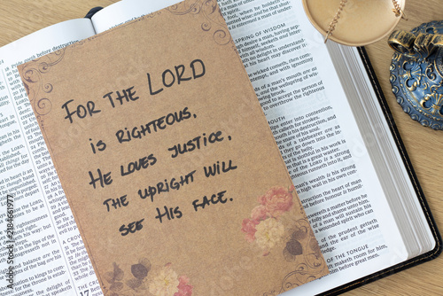 Foto Handwritten quote for the LORD's righteousness and justice on rustic paper with holy bible and balance scales