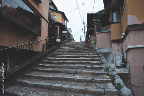 Old stone stairs alley leading up through traditional Japanese buildings in Kyoto, Japan.