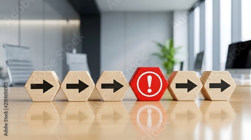 Naklejka Hexagonal wooden blocks with arrows interrupted by a red exclamation mark on a desk, symbolizing business risks, process errors, and management obstacles.