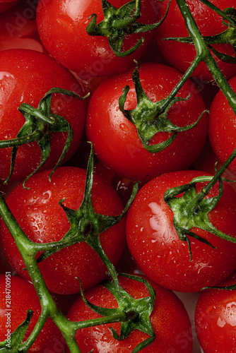 Картината върху платно Close-up of fresh juicy cherry tomatoes on the vine, showcasing their vibrant re