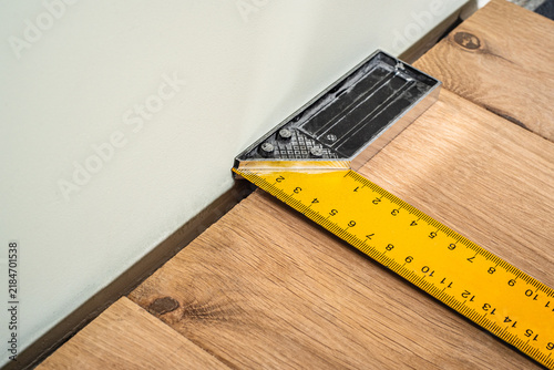 Mandatory expansion gap measurement between wall and natural solid oak floor plank