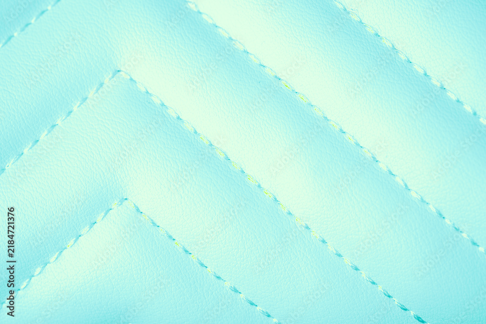 Obraz premium Soft light blue quilted fabric texture with a distinctive diagonal zigzag stitching pattern background