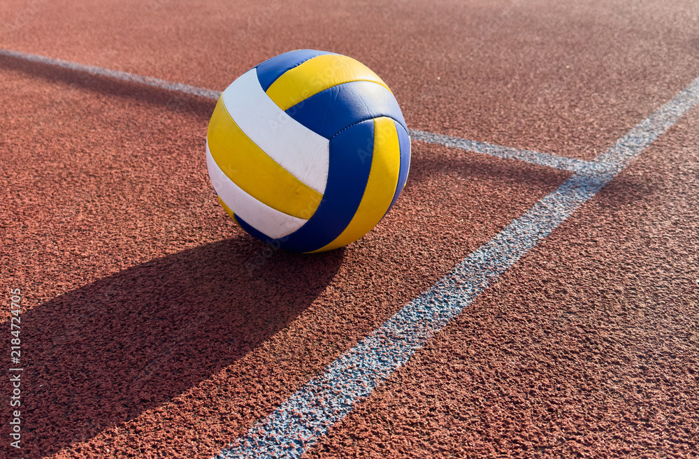 Fototapeta premium volleyball. blue with yellow color ball on the playground. volleyball cover, red. ball game