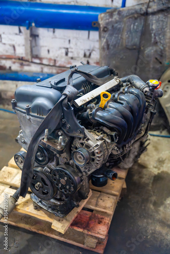 Bild auf Leinwand Removed car engine with intake manifold and alternator in auto repair workshop