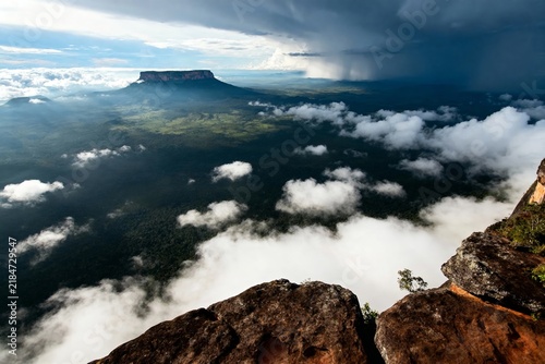 Aerial view of a plateau rising above a sea of clouds with dramatic stormy skies