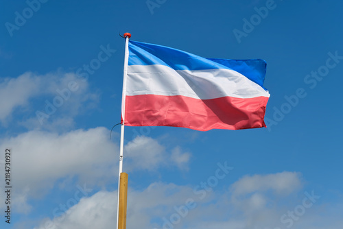 Dutch red white and blue upside down flag protest sign against a blue sky. Farmers in the Netherlands protesting against forced shrinking of livestock because of CO2 emissions.	