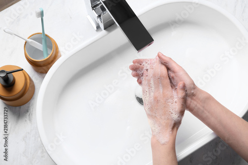 Foto Hand hygiene and disease prevention, person washing hands with soap and foam in