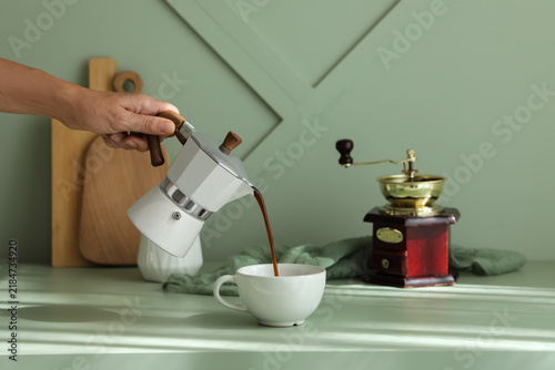 Картината върху платно Morning coffee ritual and home lifestyle, person pouring fresh espresso from a m