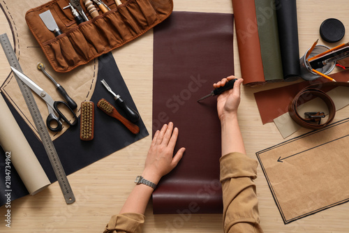 Принти на полотні Leather craft and artisan workshop, person marking leather hide with awl for han