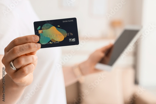Woman with credit card and tablet computer at home, closeup