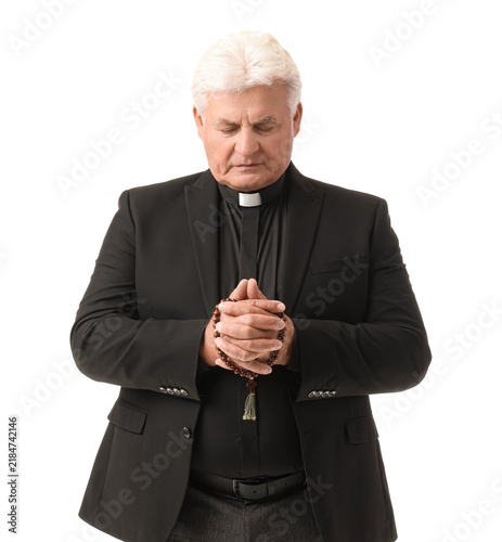 Canvas Print Senior priest praying with beads on white background