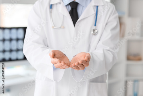 Male doctor holding something in clinic, closeup