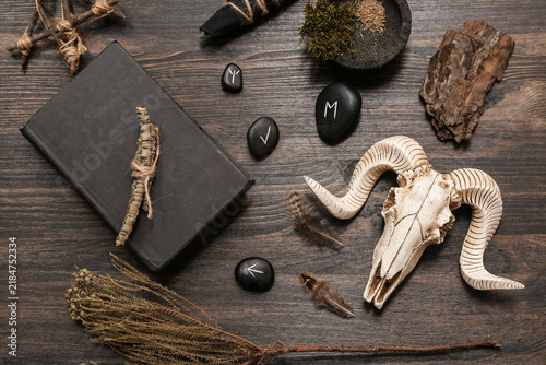 Foto Shamans accessories with sheep skull and runes on dark wooden background