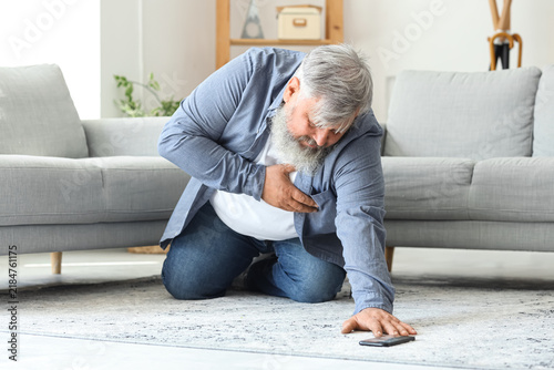 Mature man with heart attack trying to call an ambulance