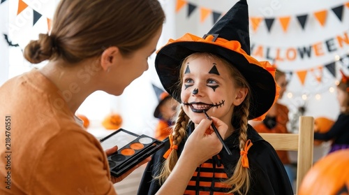 Mother Applying Halloween Face Paint to Daughter Dressed in Witch Costume for Festive Home Party Celebration