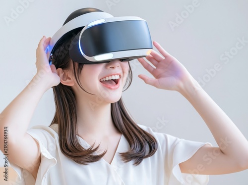 Fototapeta VRヘッドセットを装着しバーチャルリアリティの世界に驚き笑顔を見せる女性