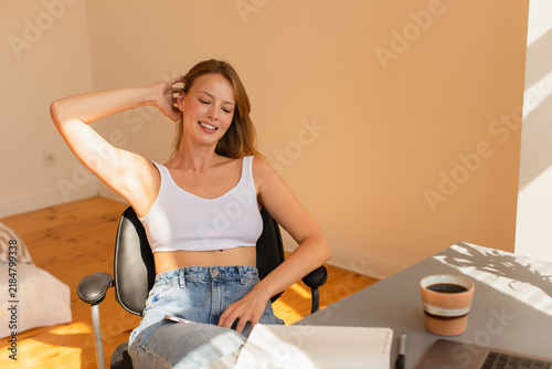 Принти на полотні A young blonde woman relaxes in her modern apartment, basking in morning light