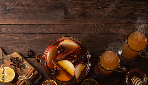Overhead View of Warm Apple Cider Drink Station with Spices on Dark Oak Surface