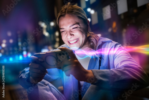 Smiling woman holds mobile device with glowing AI light in city