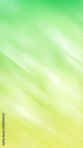 Abstract blurred motion background with diagonal light streaks in shades of lime green and yellow