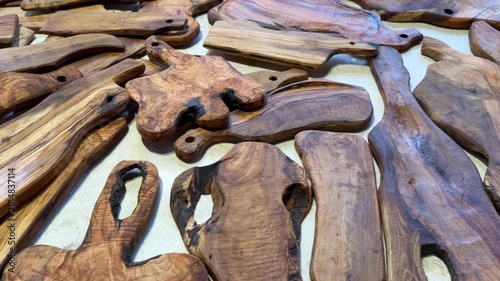Handmade wooden cutting and serving boards displayed for sale at a local market, showcasing natural wood grain and traditional craftsmanship