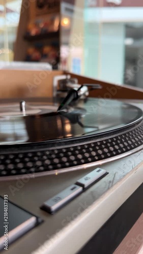 Close-up video of a vinyl record spinning on a turntable in a cafe, illustrating analog music playback and vintage audio technology