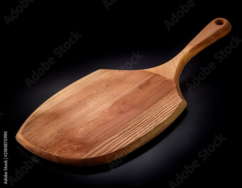 a wooden pizza peel on a black background