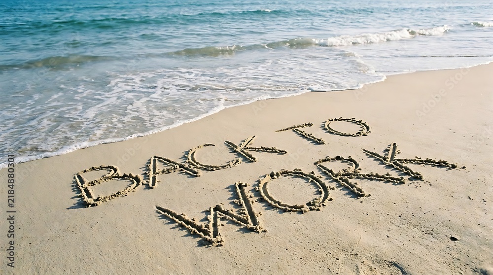 Fototapeta premium The words back to work are written in the sand on a beach with gentle waves washing up on the shore under a bright, clear blue sky