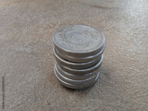 фотографія Stack of circular metal discs resting on a textured concrete surface with natura
