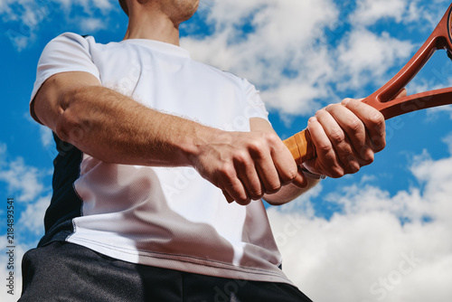 Fotografía Caucasian young adult man holding tennis racket preparing for two handed backhand stroke outdoors