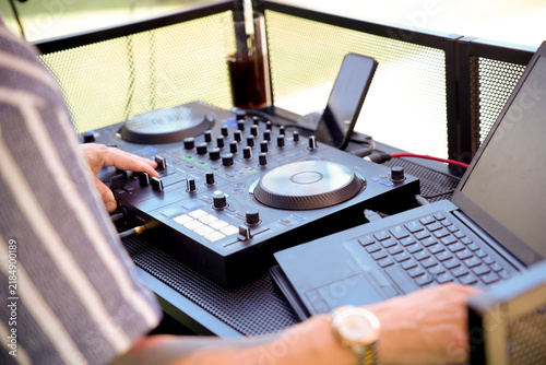 Dj mixing music on professional audio controller equipment